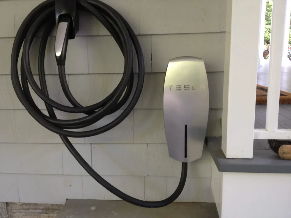 Tesla Wall Connector installed on a home exterior by Elite Electric