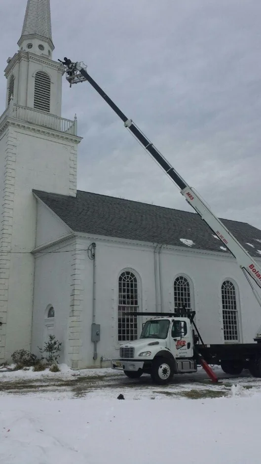 Elite Electric bucket truck servicing a church steeple in the snow